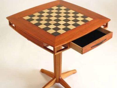 Koa Games Table
Chess or Checkers?
Koa & Maple
Top measures: 27" x 27"
Table Height: 29"
Board size: 17" x 17"  featuring Holly and black dyed Anigree squares
Two Maple and Koa accent drawers offer ample storage for game pieces.
Drawer size: 13.25" x 11.75" x 1.5"